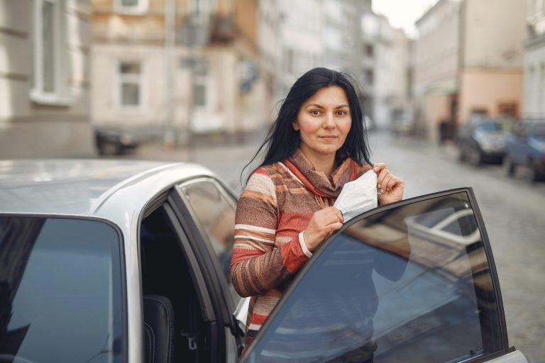 woman getting out of car looking at camera